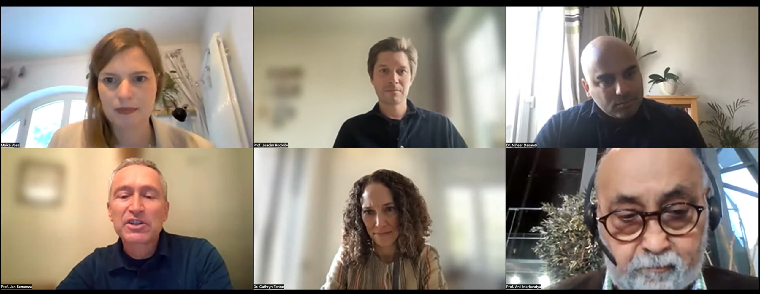 Screenshot of a virtual meeting with six participants displayed in a 3x2 grid, each in different indoor settings.